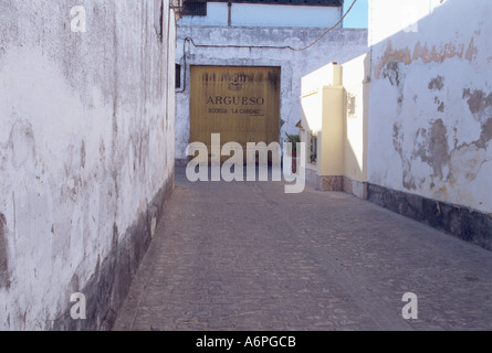 narrow street running between maturing cellars on wineries in Sanlucar de Barrameda Andalusia Spain Stock Photo