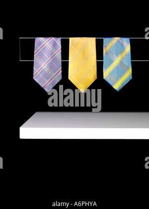 ABSTRACT PHOTOGRAPH OF THREE TIES HANGING ON A BLACK BACKGROUND Stock Photo