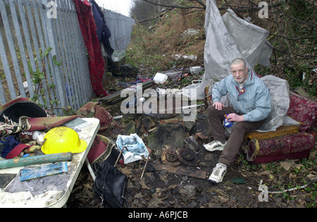 Homeless man in settles down to prepare a meal in his make shift camp Luton Beds UK Stock Photo