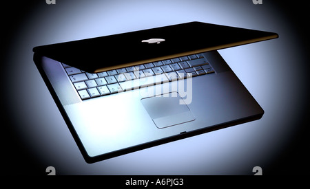AN APPLE MAC LAPTOP ON BLACK BACKGROUND WITH WHITE HALO OF LIGHT Stock Photo