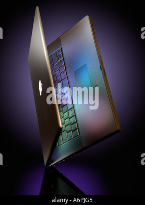 AN APPLE MAC LAPTOP BALANCING ON ITS CORNER WITH COLOURED REFLECTIONS Stock Photo