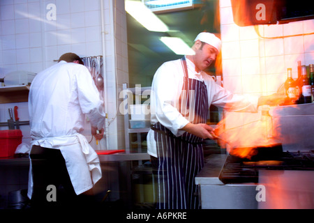 TWO PROFESSIONAL CHEFS WORKING IN COMMERCIAL KITCHEN Stock Photo