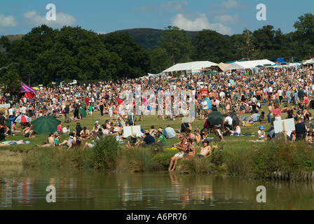 Crowds of party goers reflected in the lake at the Big Chill music and dance festival Eastnor Castle Herefordshire Stock Photo