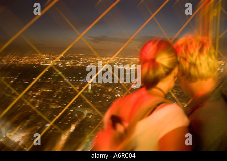 Young couple embracing and admiring view top observatory Eiffel Tower Paris France Motion blurred image Europe Stock Photo