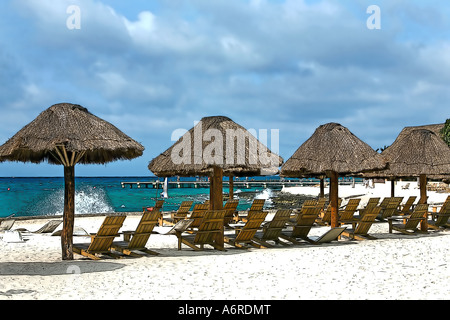 Cozumel beach chairs pier and sand near splash of ocean Stock Photo