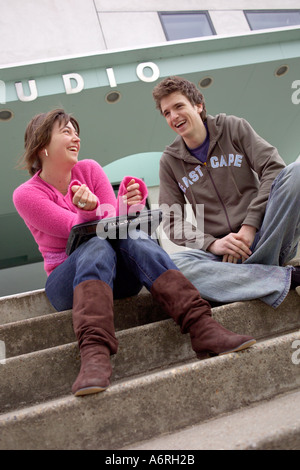 Students chatting sttting on steps in campus in between lectures Stock Photo