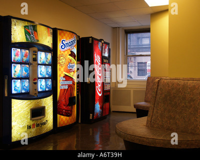 Soft drink vending machines in a lobby or foyer area by artificial light.