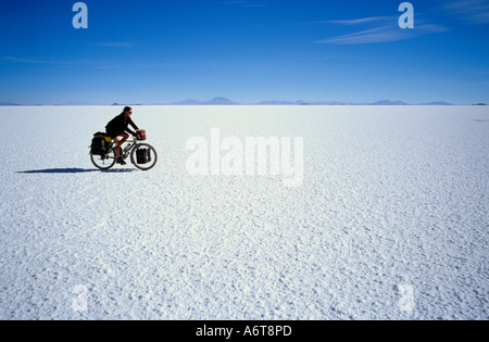 female expedition touring cyclist alone on salt flat of Salar de Uyuni at 3600 metres in Bolivia Stock Photo