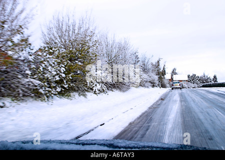 Taken from the inside of a vehicle moving along a road in the ice and snow Stock Photo