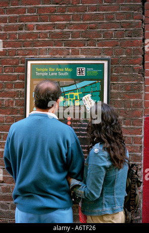 A tourist couple pause to look at a map of Temple Bar Dublin Ireland Stock Photo