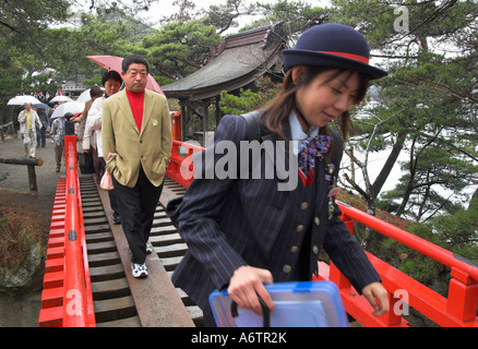 Japan Nothern Honshu Miyagi ken Matsushima bay female tourist guide walking accross a traditional red bridge Stock Photo