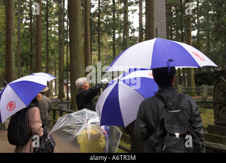 Japan Nothern Honshu Miyagi ken Matsushima bay Zuigan ji temple group of touists and guide with blue and white umbrellas Stock Photo