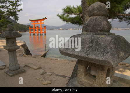 Japan Western Honshu Miyajima Itsuku shima jinja floating torii wide view with traditional stone candle stands in frgd Stock Photo