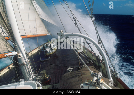 The foredeck of the three masted staysail Schooner Aquarius W as she powers through a wave in the Atlantic ocean Stock Photo