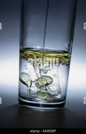 Oil poured in glass of water Stock Photo