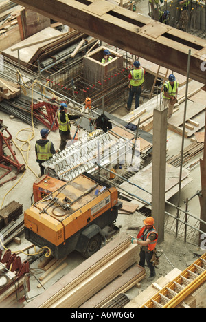 Building construction site deep foundations for new office block under construction carpenters and other trades preparing formwork London England UK Stock Photo