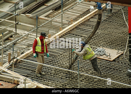 Aerial view steel reinforced foundations new office block building construction site ready mix concrete placed by pump from flexible hose London UK Stock Photo