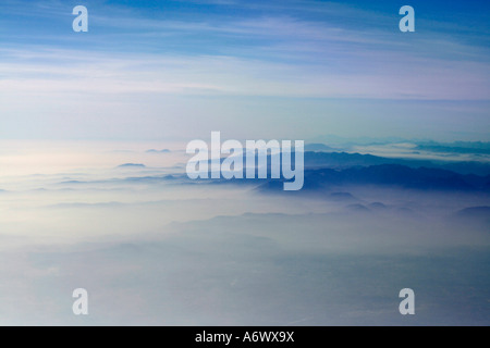 Gorgeous view of sky, mountains and clouds seen from a plane in flight Stock Photo