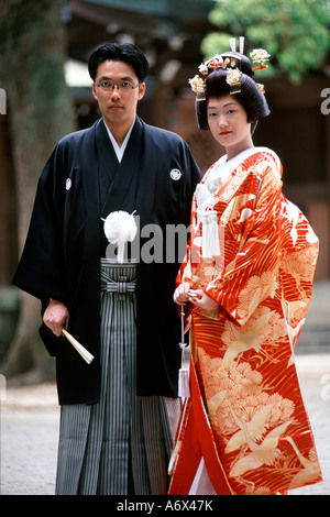 A Japanese couple pose for photos after their traditional wedding held in the Meiji Shrine in Tokyo Japan. Stock Photo