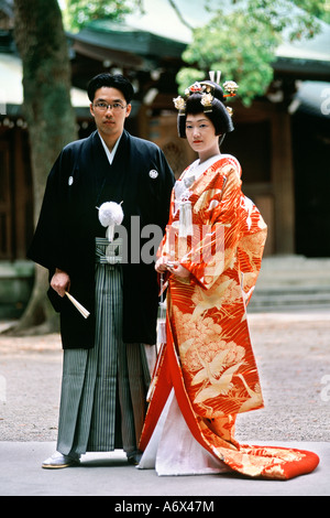 A Japanese couple pose for photos after their traditional wedding held in the Meiji Shrine in Tokyo Japan. Stock Photo