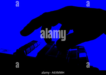 abstract silhouette of male hand on computer keyboard Stock Photo