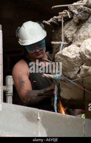 Man using angle grinder on reinforced concrete during building redevelopment Bradford Stock Photo