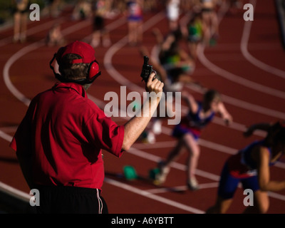 Race official holding a starting gun at the beginning of a track event Stock Photo