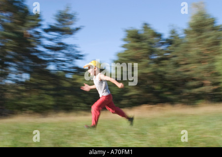 Six year old boy running with outstretched arms Stock Photo