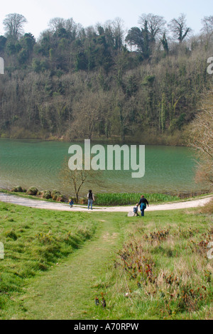 Family walking around the edge of Swanbourne Lake, Arundel, Sussex, UK Stock Photo