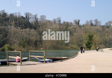 Family walking around the edge of Swanbourne Lake, Arundel, Sussex, UK Stock Photo