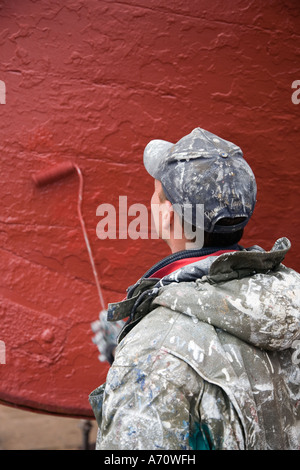 Workmen Boat painting. Ships, nautical, transport, fishing, wooden, painter at MacDuff ship & fishing boat repair yard north-east Scotland UK Stock Photo