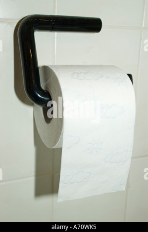 Toiletpaper on a holder hanging on the wall Stock Photo