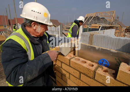 Experienced older bricklayer laying bricks on a housing development Stock Photo