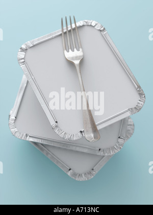 Stack of three take away trays and fork on pale blue background - high end Hasselblad 61mb digital image Stock Photo