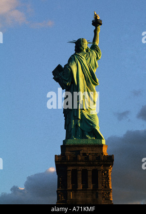 Statue of Liberty sunset, New York City landmark historic monument full figure on a pedestal, rear view. Liberty Island, Lower Manhattan, USA Stock Photo