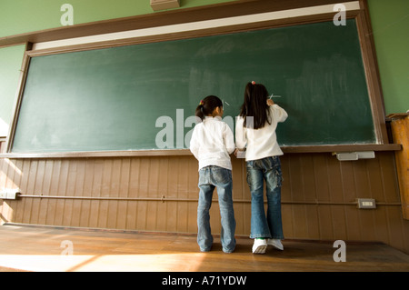 Children writing on blackboard Stock Photo
