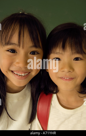 Two elementary school girls smiling in library Stock Photo - Alamy