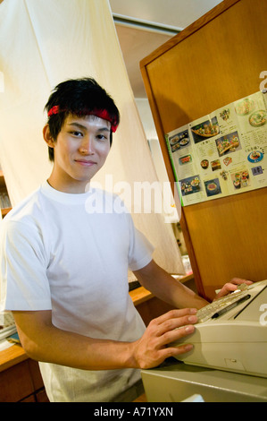 Young man working on cash register Stock Photo