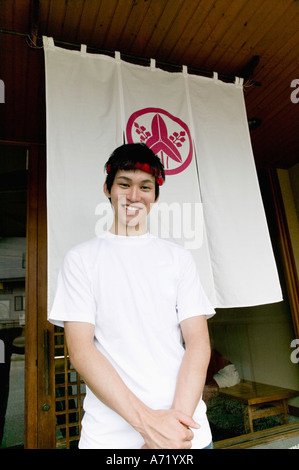 Young man standing in front of restaurant Stock Photo