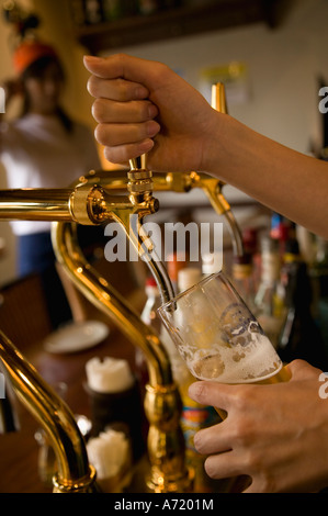 Bartender pouring beer to glass Stock Photo