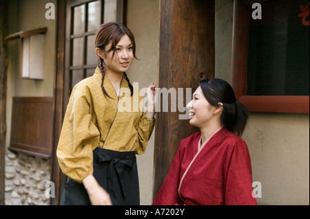 Two young women talking in front of restaurant Stock Photo