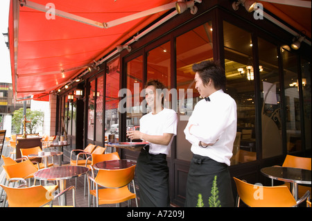 Two waiters standing in front of coffee shop Stock Photo