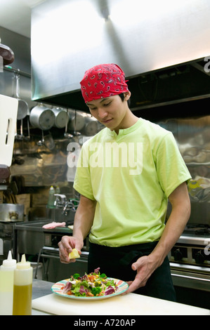 Young man making salad Stock Photo