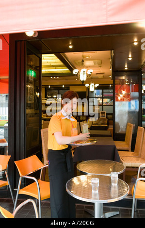 Waitress carrying drinks on tray Stock Photo