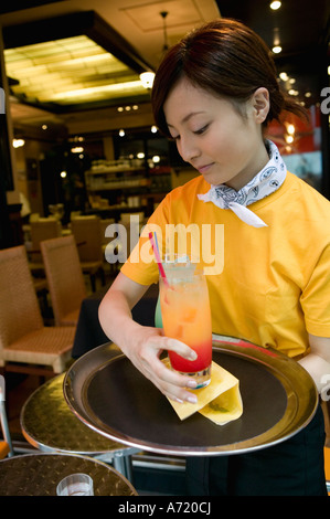 Waitress carrying drinks on tray Stock Photo