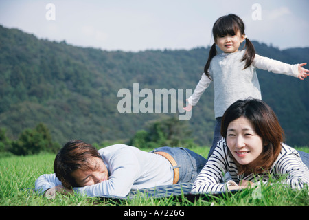 Family lying down on ground Stock Photo