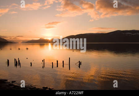 Warm sunset light over Loch Ness on a tranquil winter evening Dores near Inverness Scotland Stock Photo