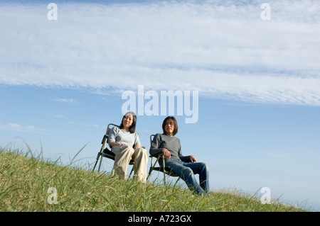 Young couple sitting in chairs Stock Photo