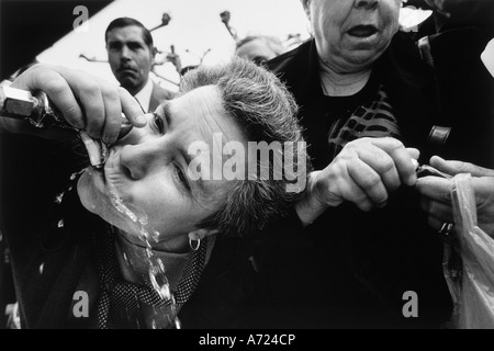 LOURDES FRANCE Drinking Lourdes water from a tap. Almost a million come annually to drink and bathe in the waters of the spring Stock Photo