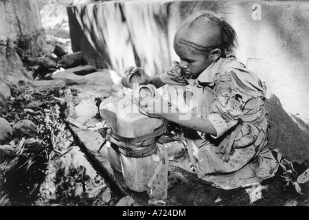 A young girl fills her water bottle Stock Photo